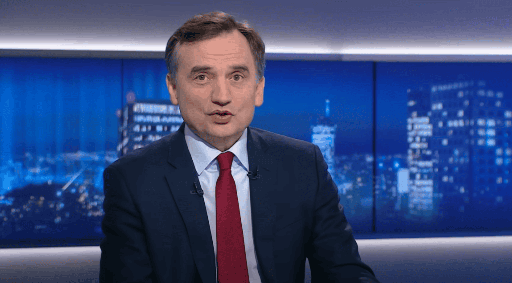 Radio TV news presenter in a formal suit, sitting at a news desk with cityscape background at night, delivering news.